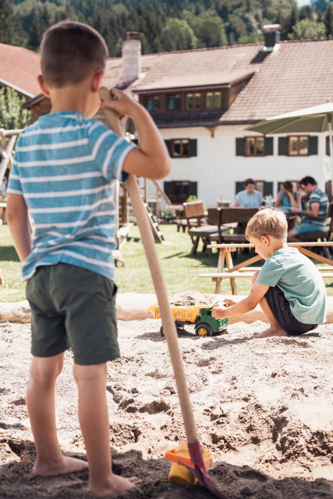 Kinder spielen auf einem Bauernhof im Sandkasten